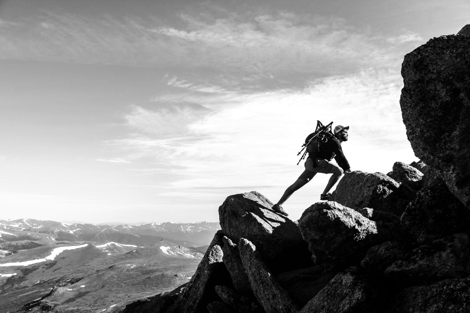 black and white photo of a man rock climbing on mountain