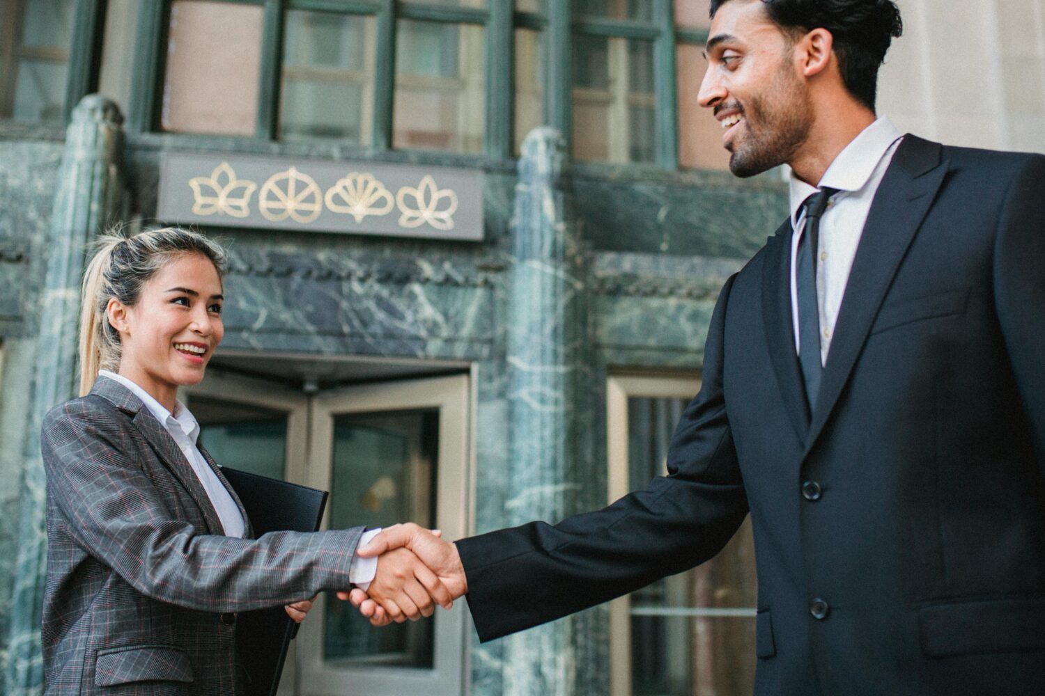 Woman and man in office suit shaking hands