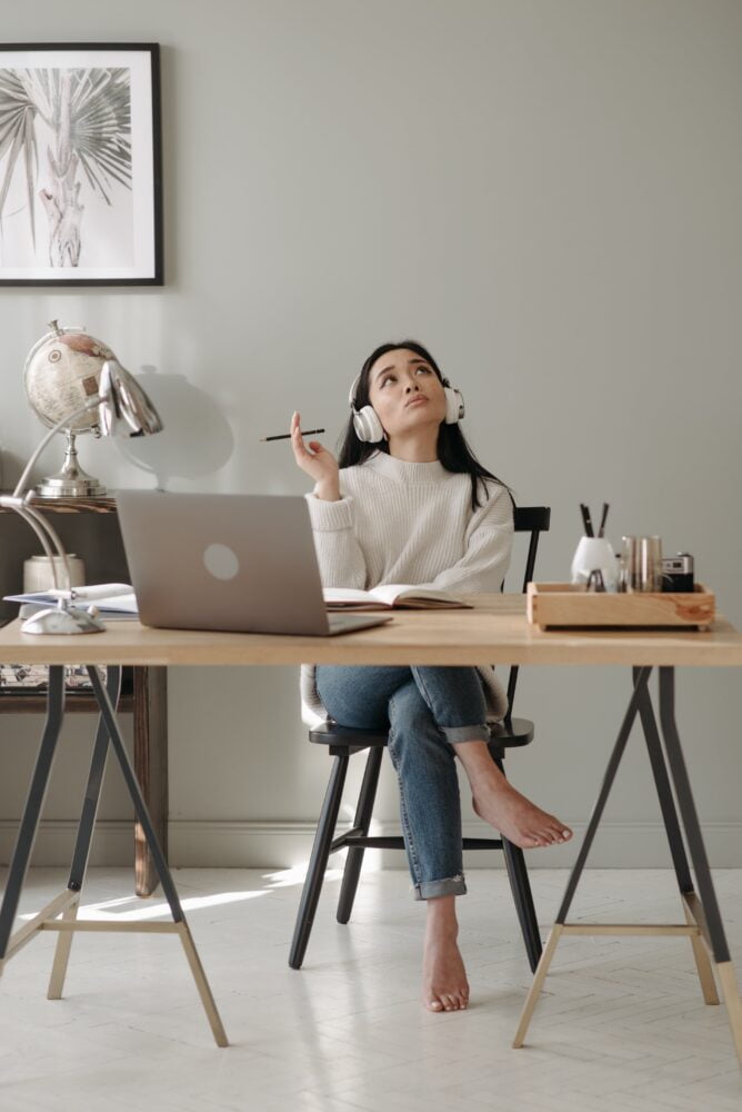 A woman on her desk thinking where to find a speaking coach